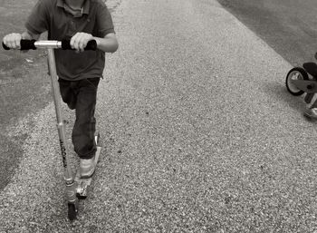 Low section of man skateboarding on road