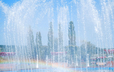 Fountain in city against sky