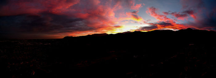 Scenic view of silhouette mountains against orange sky