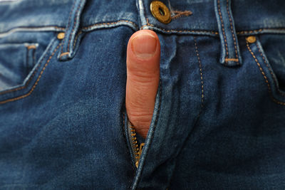Cropped hand of person in jeans zipper