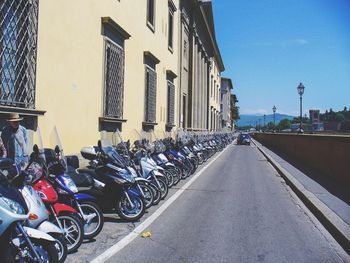 Bicycles on road in city against sky