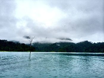 Scenic view of lake against cloudy sky