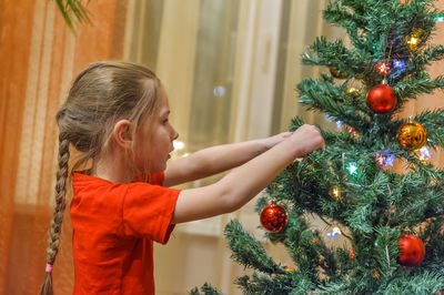 Rear view of girl with christmas tree