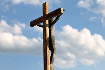 Low angle view of cross on wood against sky