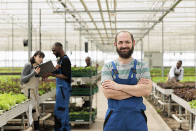 Portrait of young woman standing in greenhouse