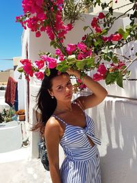 Beautiful young woman standing by flowering plants