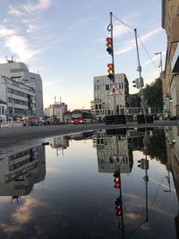Reflection of buildings in puddle on river
