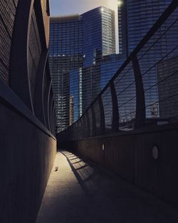 Empty footpath amidst buildings in city