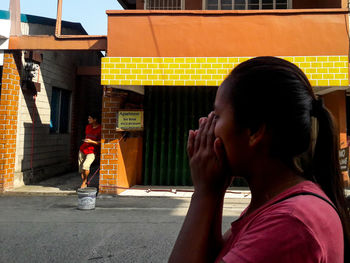 Side view of people on street against buildings in city