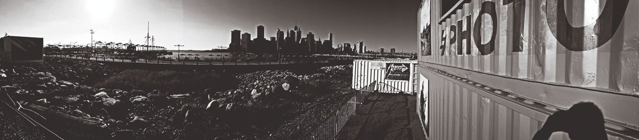 architecture, built structure, building exterior, railing, transportation, city, clear sky, bridge - man made structure, sunlight, building, sky, the way forward, outdoors, day, connection, no people, street, low angle view, road, diminishing perspective