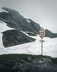 Snow on road by mountain against sky