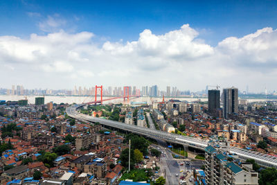 High angle view of bridge amidst buildings in city against sky