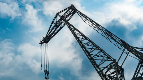 Low angle view of crane against sky