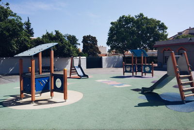 Empty playground against trees in park