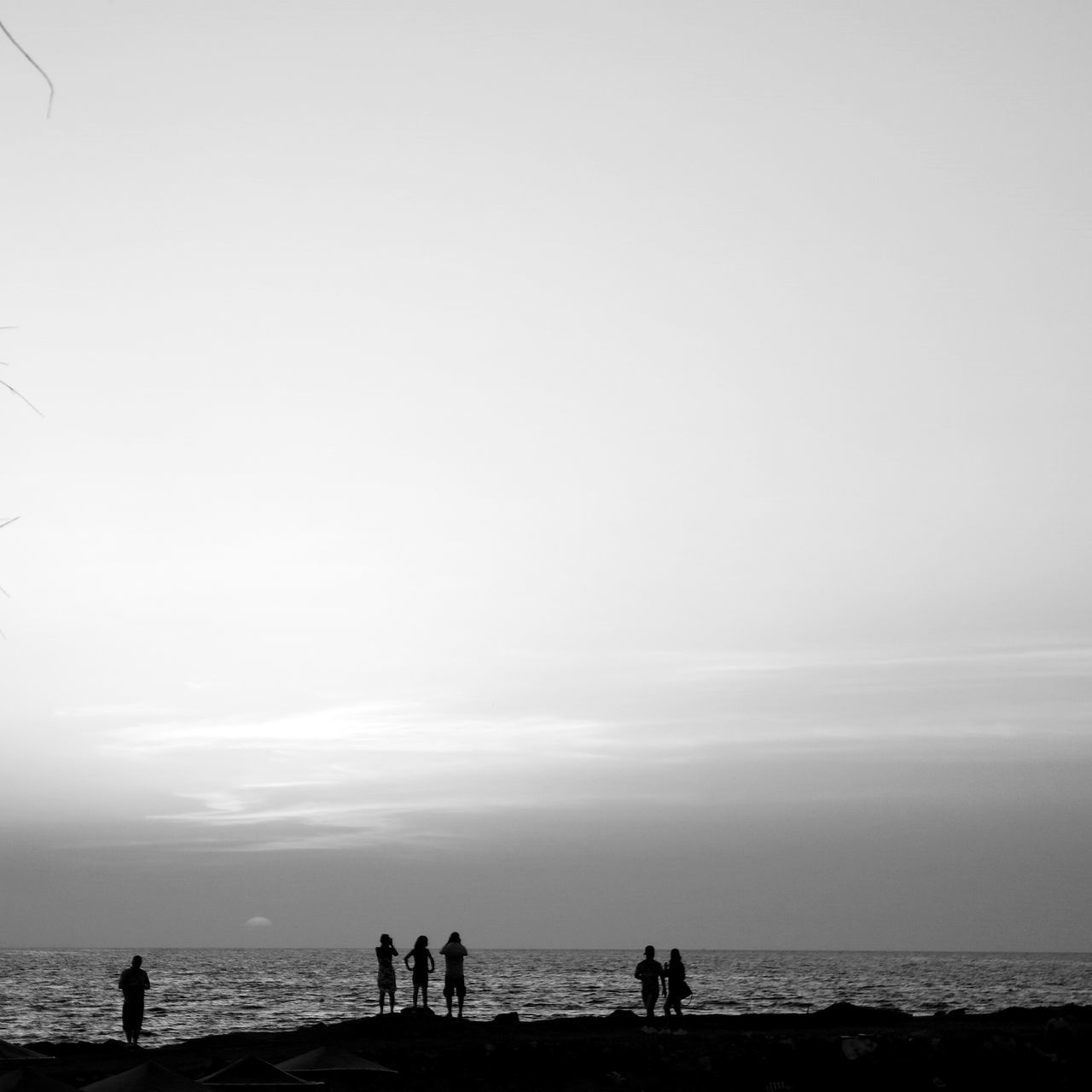 sea, horizon over water, water, beach, sky, silhouette, lifestyles, scenics, leisure activity, shore, men, tranquil scene, togetherness, beauty in nature, tranquility, nature, vacations, medium group of people