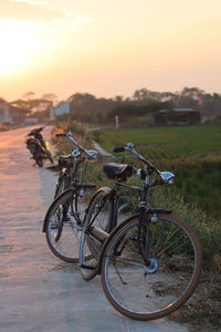 Bicycle parked on street in city during sunset