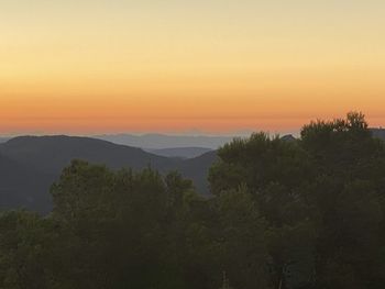 Scenic view of mountains against orange sky