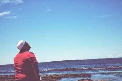 Rear view of woman standing on shore