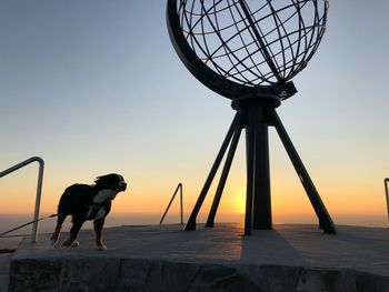 Silhouette dog sculpture against sky during sunset