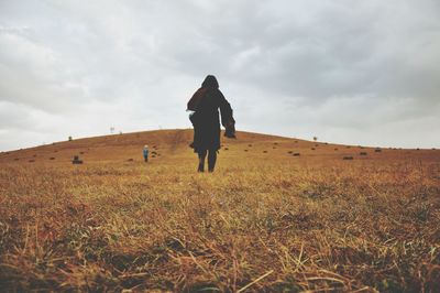 Full length of person walking on field against sky