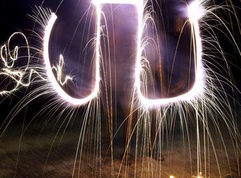 Close-up of illuminated fireworks against sky at night