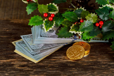 High angle view of money with leaves on wooden table