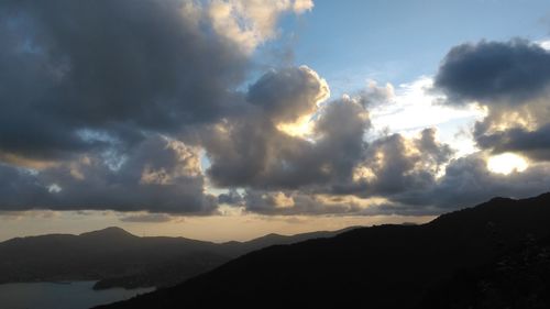Scenic view of dramatic sky over silhouette mountains