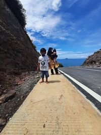 Rear view of people on mountain against sky