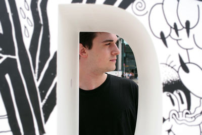 Young woman looking through window