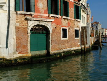 Canal by old building in city