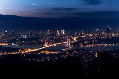 Illuminated cityscape against sky at night