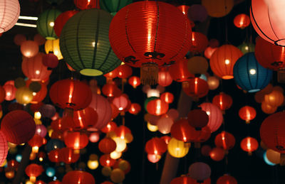 Low angle view of illuminated lanterns hanging at night