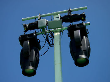 Low angle view of electric lamp against clear blue sky