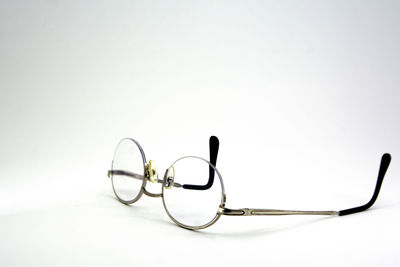 Close-up of eyeglasses on table against white background