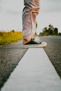 Low section of man standing on road