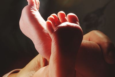 Cropped hand holding baby feet