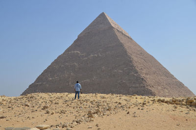 Man standing against pyramid