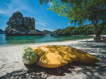 Yellow kayaks on white sand beach of breathtaking rock formation island, mu koh ang thong, thailand.