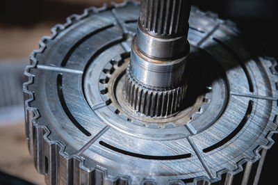 A close-up of a pack of clutches on a shaft with a gear from an automatic transfer case of a four