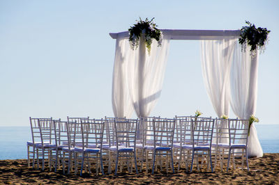 Wedding baldachine by sea against clear sky