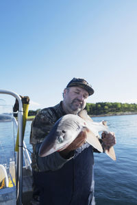 Man on boat holding fish