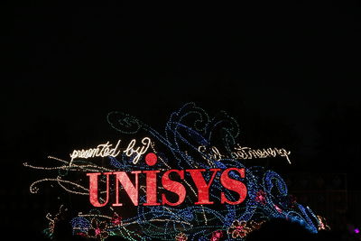 Low angle view of illuminated christmas lights against sky at night