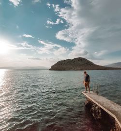 Man standing in sea against sky