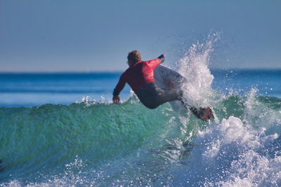 Man surfing in sea against clear sky