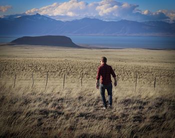 Full length rear view of man walking on field