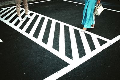 Low section of woman standing on road
