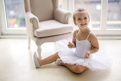 Little ballerina girl 2 years in the studio in a white tutu dress clothes