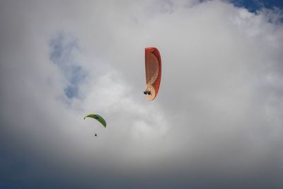 Low angle view of person paragliding against sky