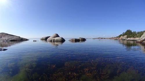 Scenic view of lake against clear blue sky