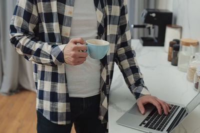 Midsection of man using mobile phone
